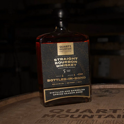 Quartz Mountain Distillers Inc. Bottle-in-Bond Bourbon bottle on barrel