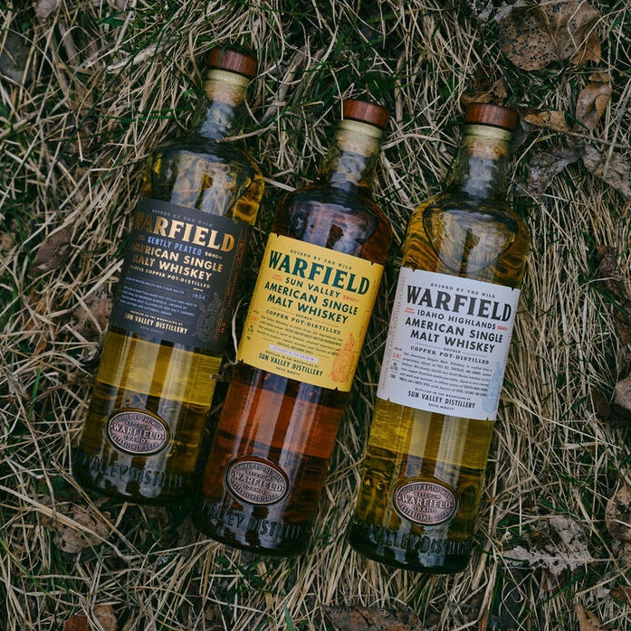 Warfield Distillery three bottles in grass